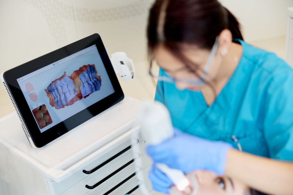 Mitarbeiterin nutzt intraoralen 3D-Scanner (CEREC) für die digitale Zahnabformung