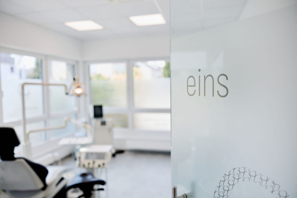Praxisflur der Zahnarztpraxis Hochzoll mit Raumbeschriftung „eins"
